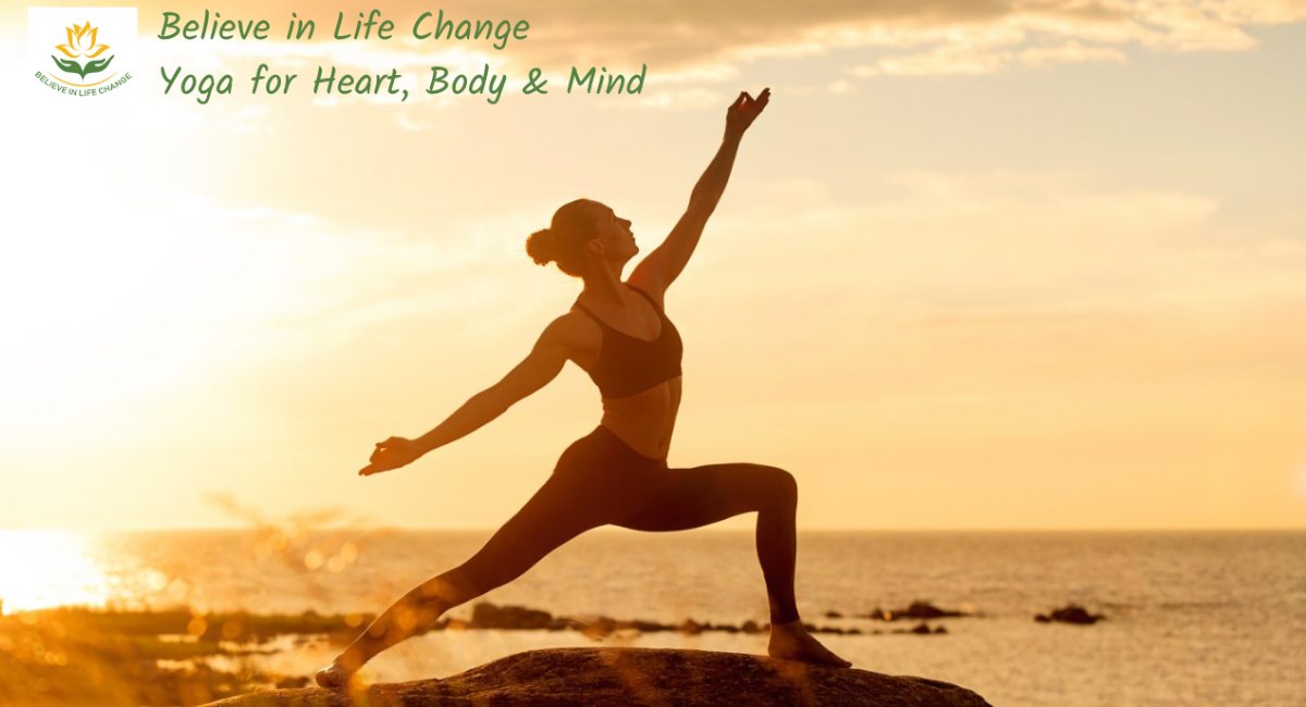 Picture of female practicing the yoga asana humble warrior on a rock by the sea at sunset